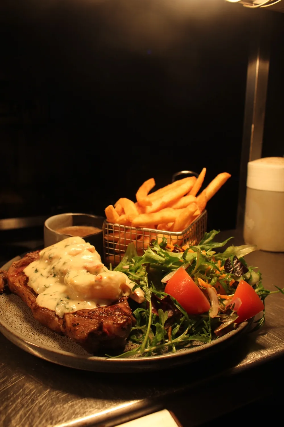A char-grilled steak with garlic butter, chips and green salad.